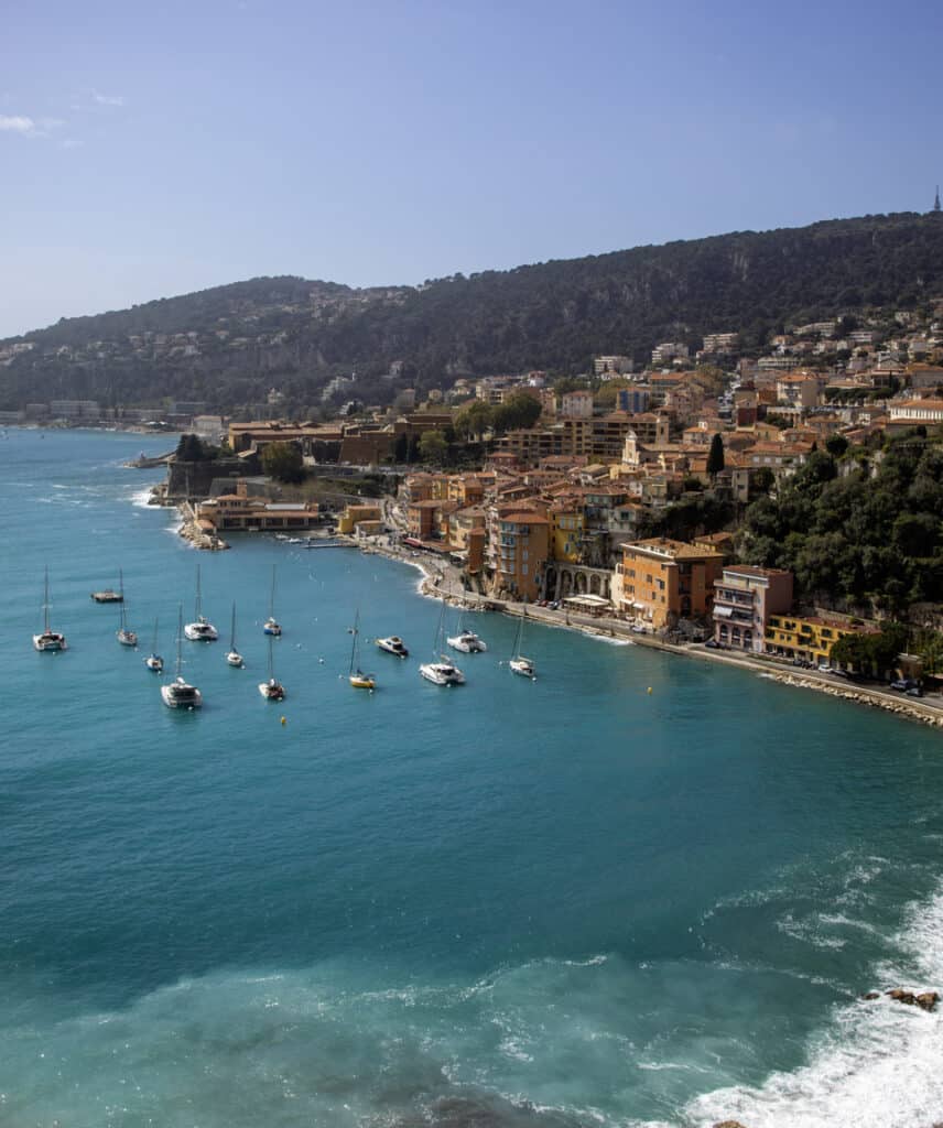 Vue panoramique sur Villefranche-sur-Mer depuis les hauteurs, illustrant l’accueil chaleureux de la ville entre mer et collines.