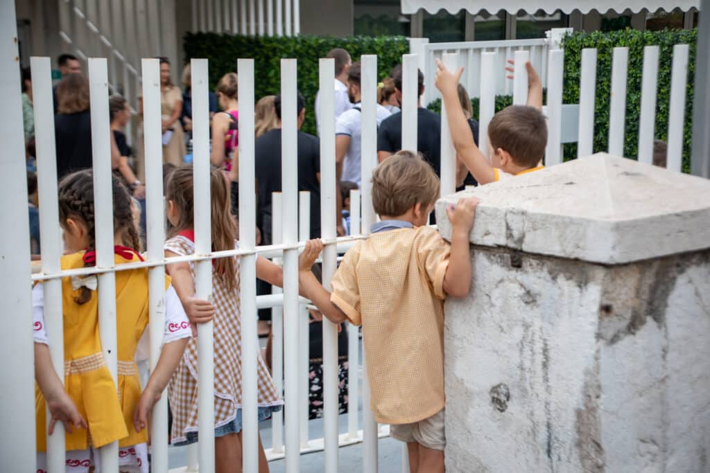 Jeunes élèves de maternelle de Villefranche-sur-Mer en train de jouer librement dans la cour , encadrés par les animatrices à proximité des barrières de l’école, durant le temps périscolaire.