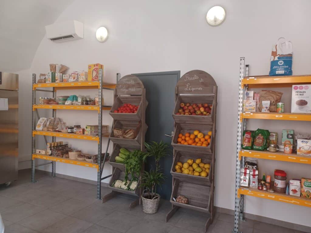 Vue intérieure de l’épicerie sociale de Villefranche-sur-Mer montrant les étagères avec des denrées alimentaires